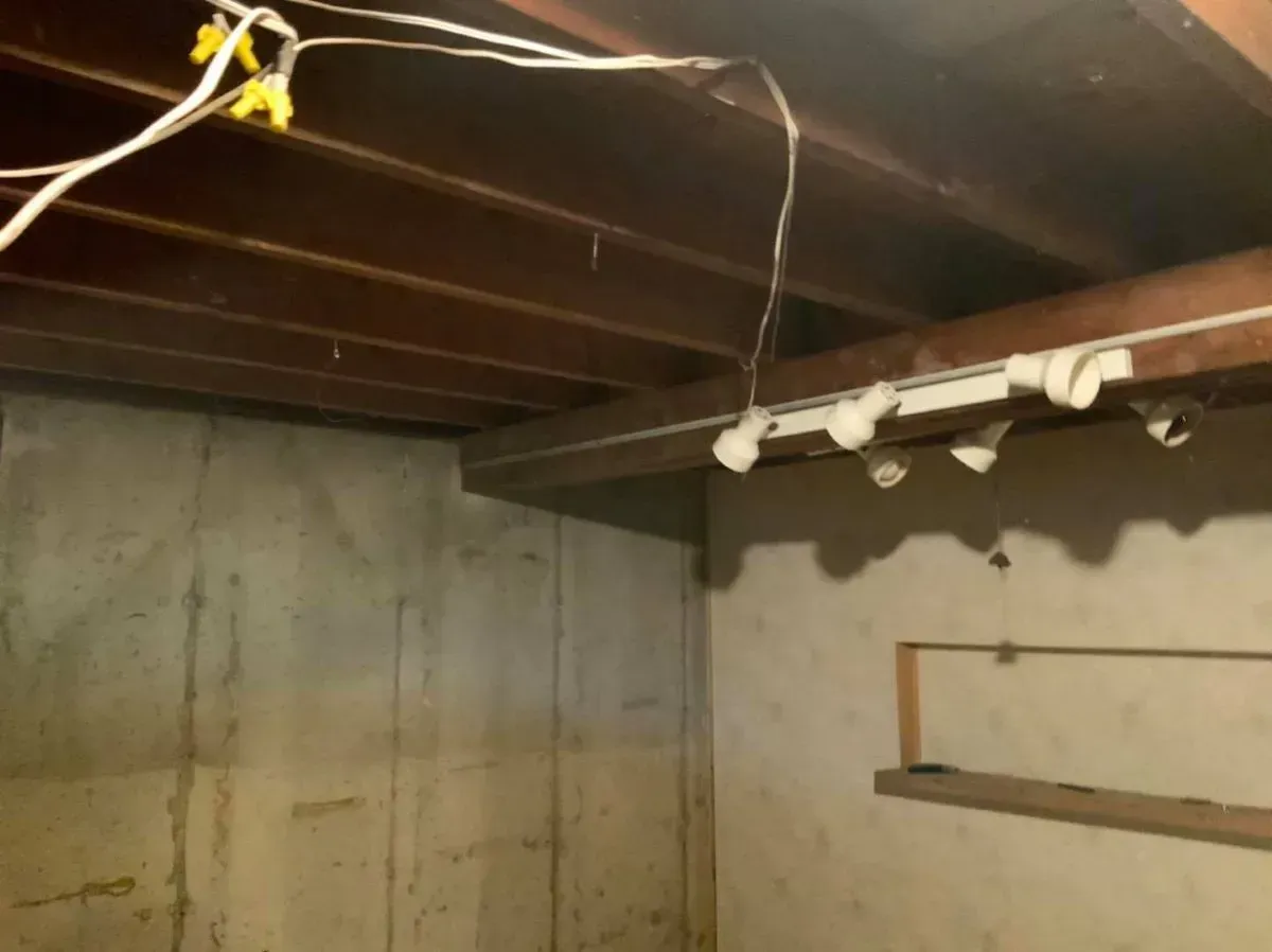 A room with a wooden ceiling and a bunch of wires hanging from it