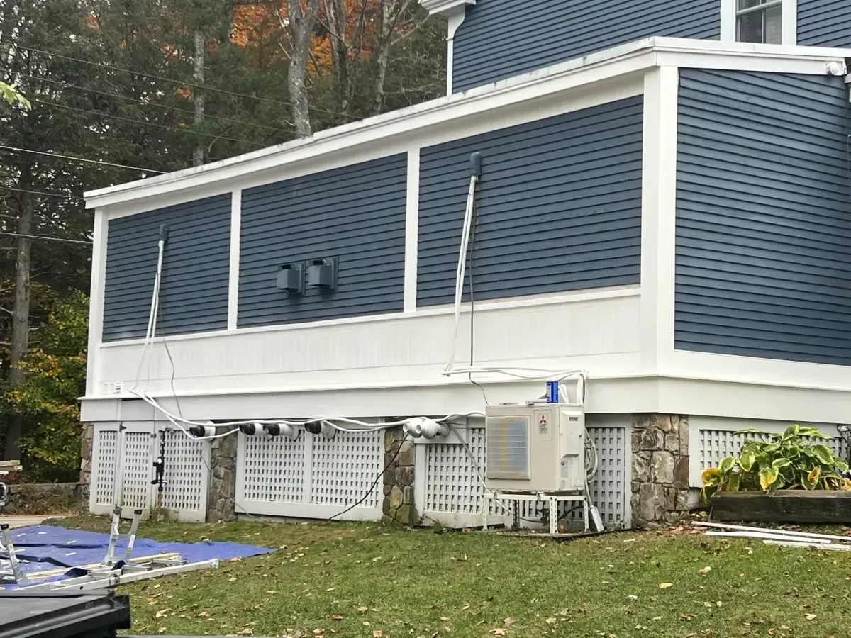 A blue house with a white porch is being painted.