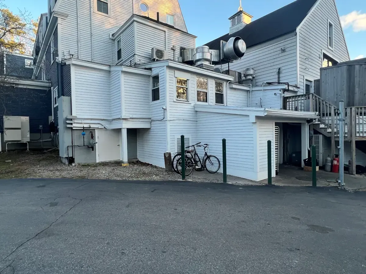 A white building with a bicycle parked in front of it.