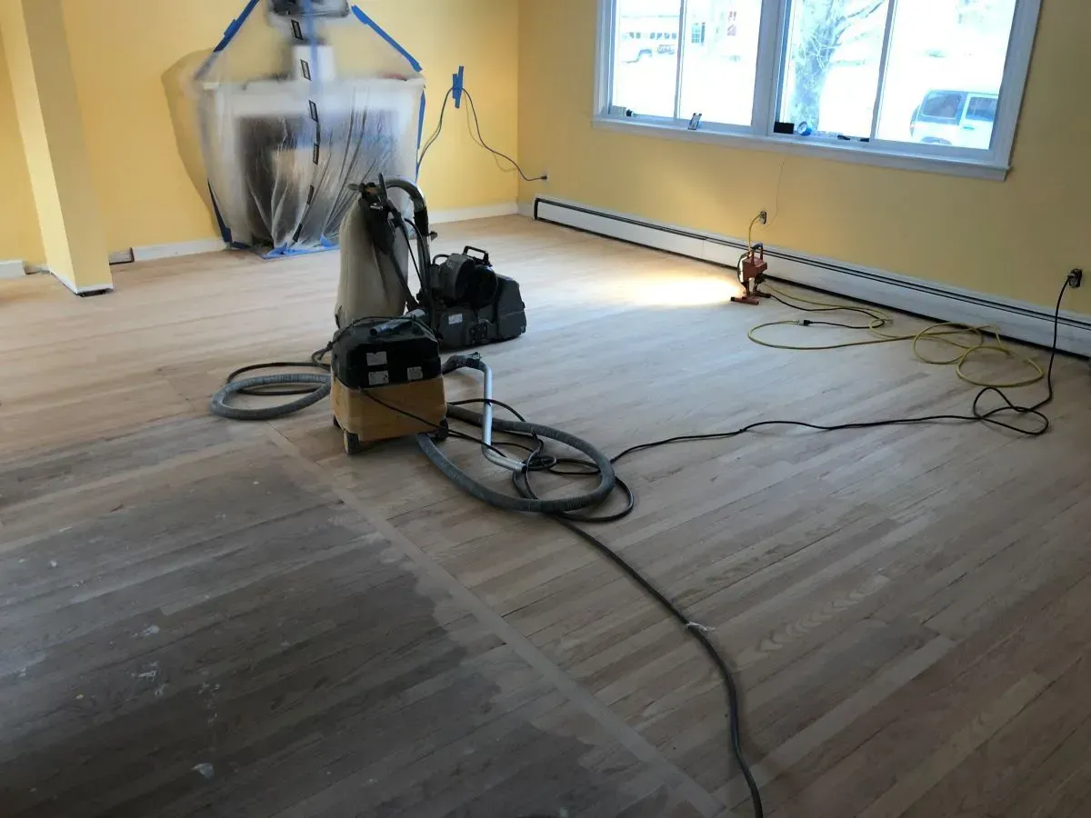A vacuum cleaner is sitting on a wooden floor in a room.