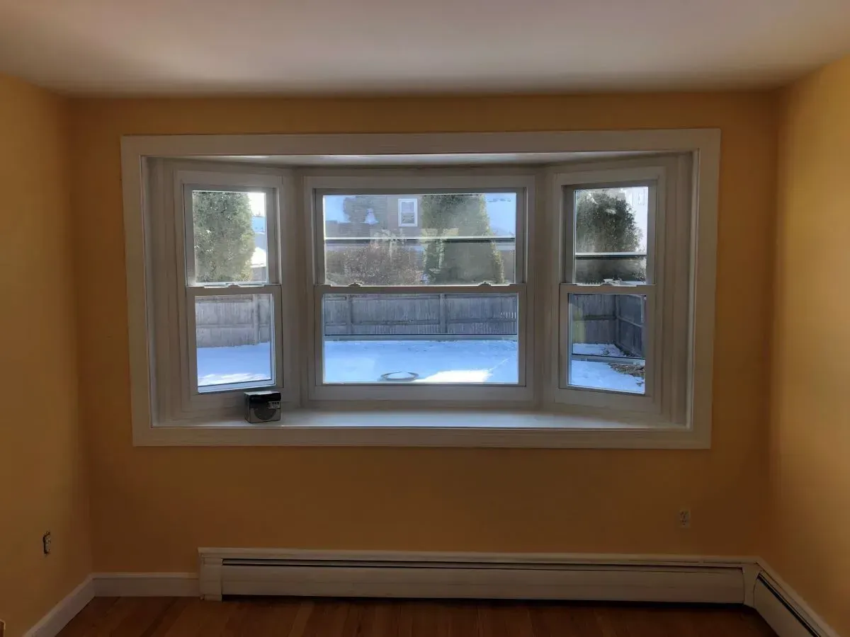 An empty room with a bay window and a radiator.
