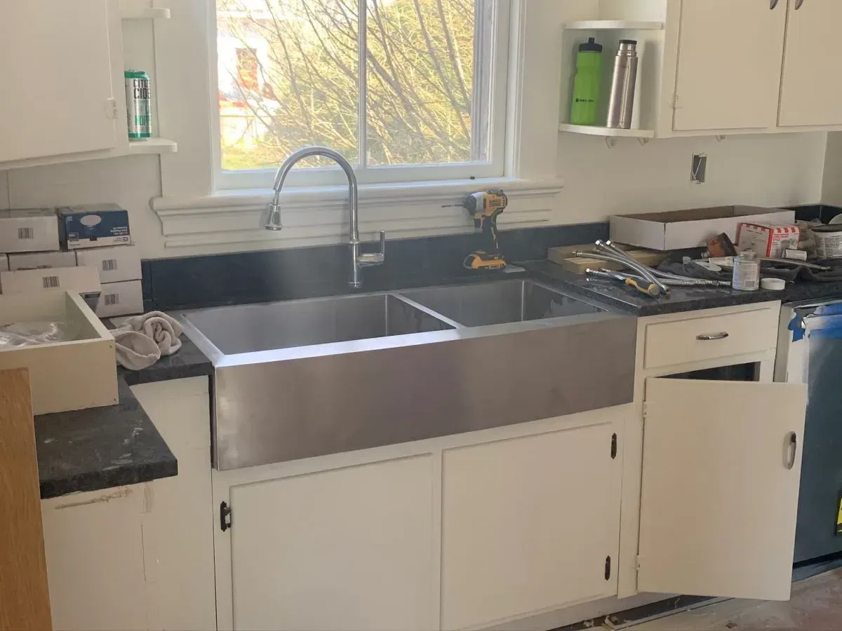 A kitchen with a stainless steel sink and a window.