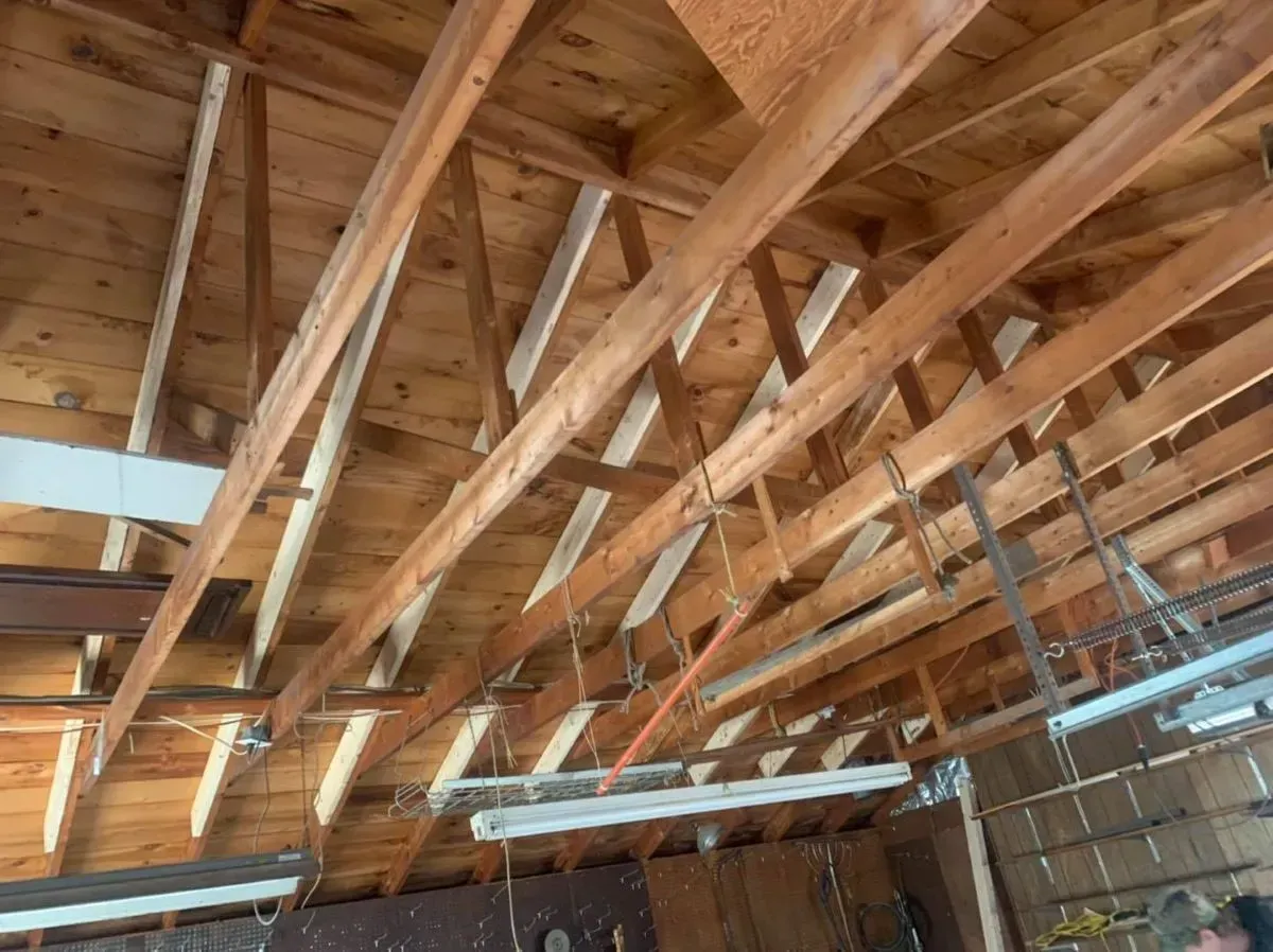 The ceiling of a building with a lot of wooden beams.