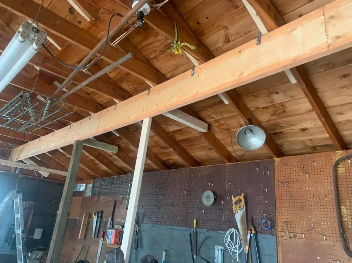 A wooden ceiling with a lot of tools hanging from it.