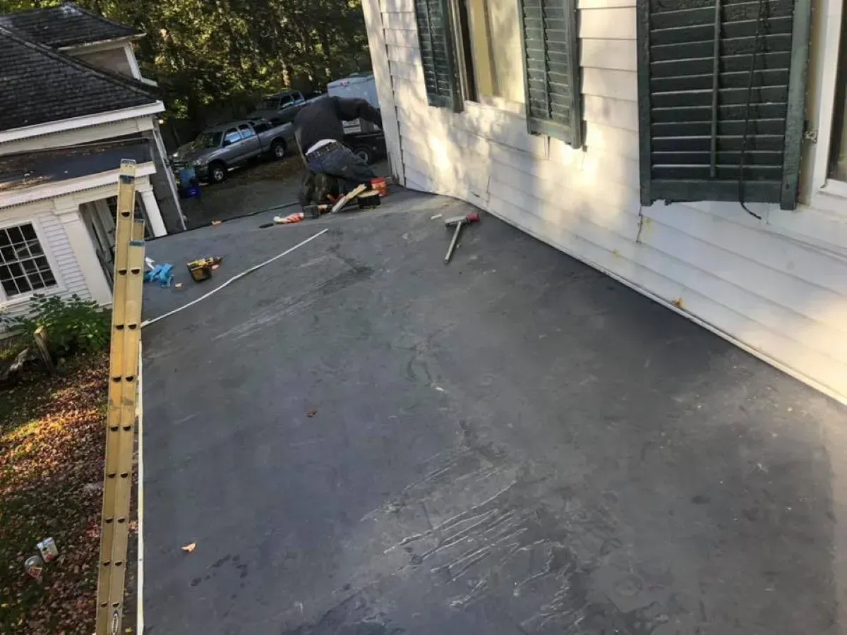A man is working on the roof of a house.