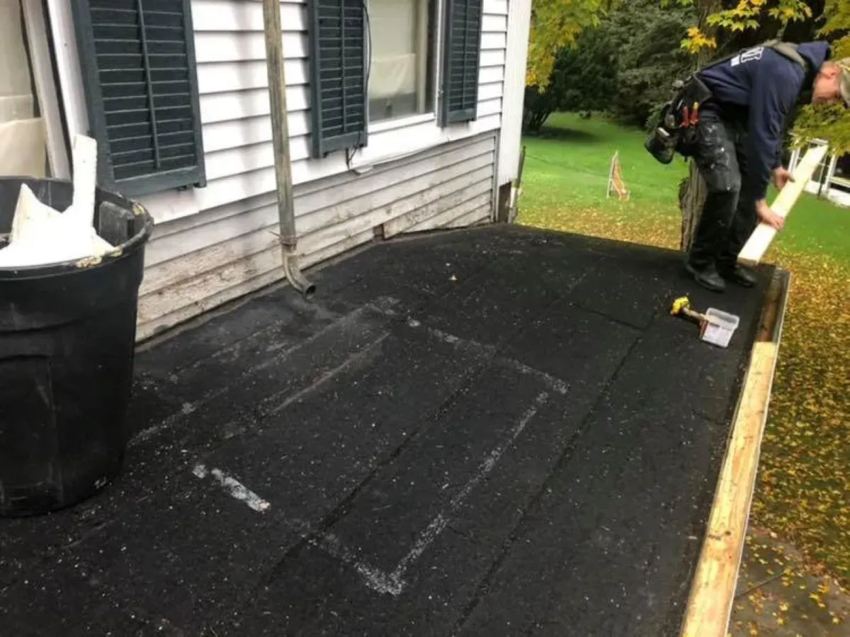 A man is working on the roof of a house.
