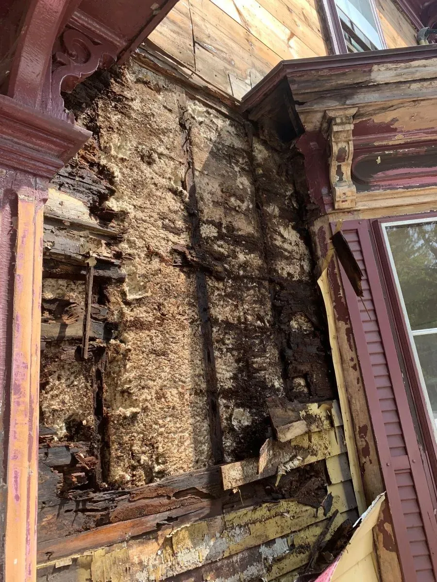 A close up of a brick wall with a window in the background.