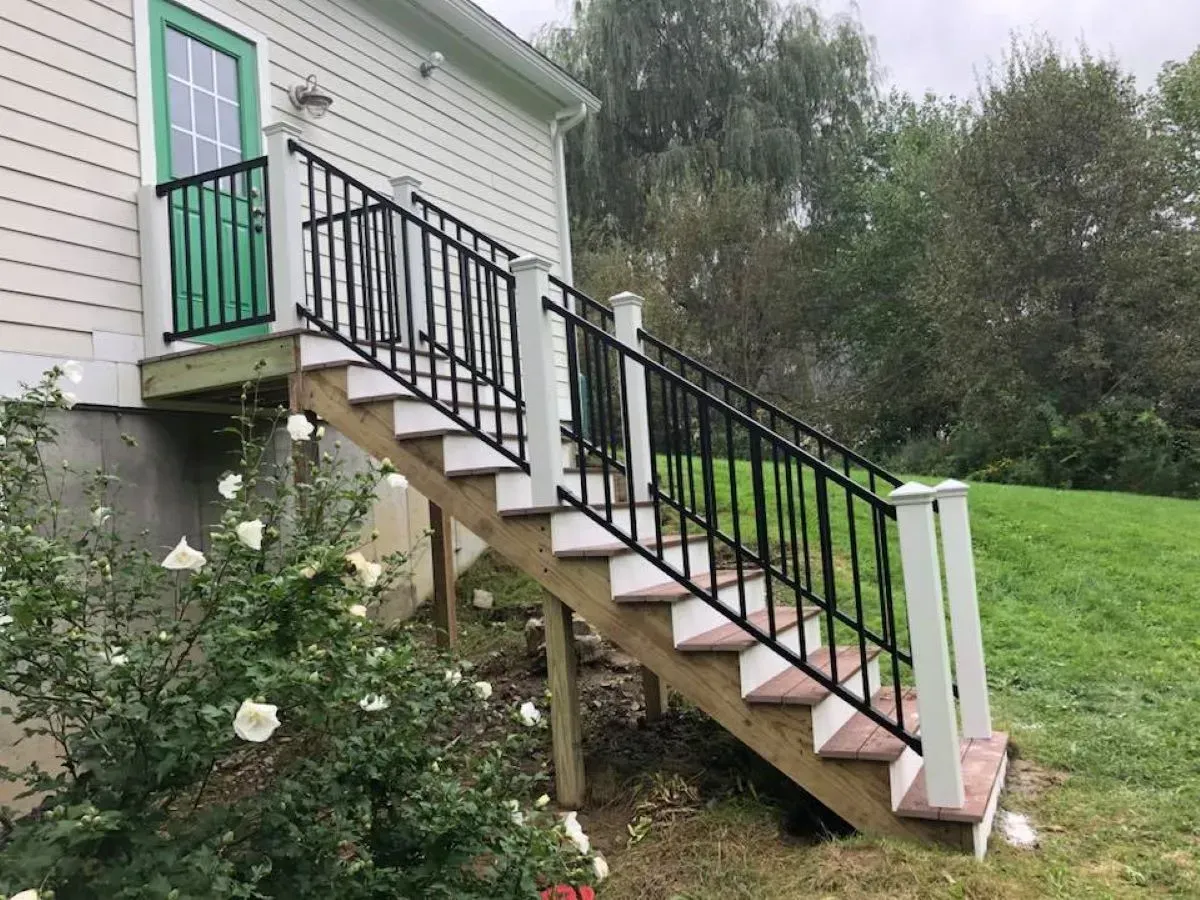 A house with a green door and stairs leading up to it.