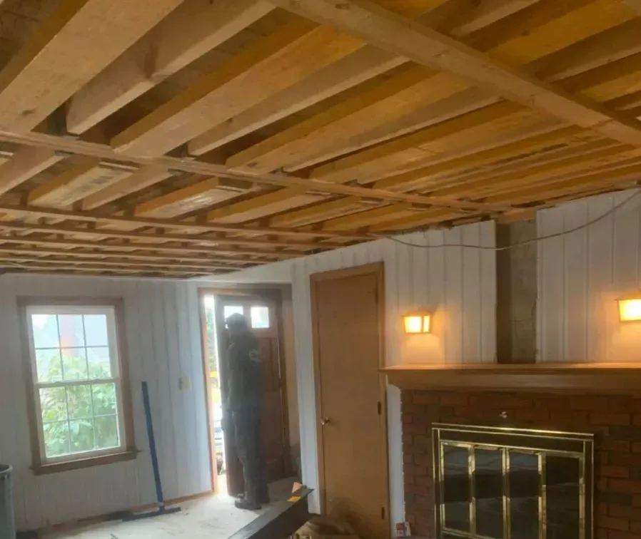 A living room with a wooden ceiling and a fireplace