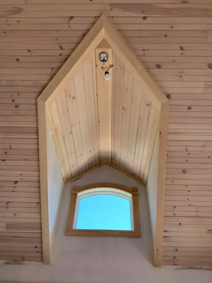 A wooden ceiling with a window in the middle