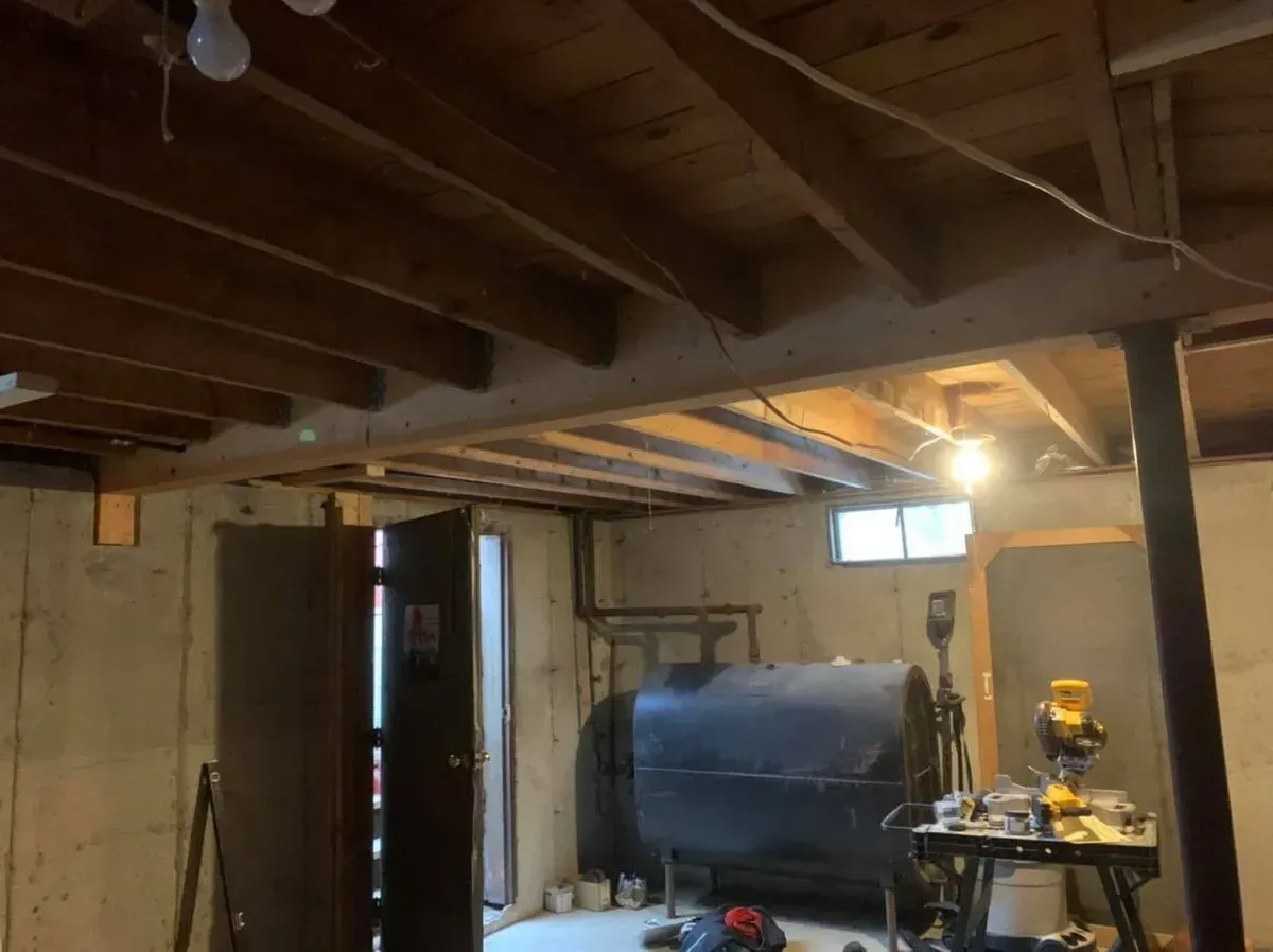 A basement with a wooden ceiling and a bbq.