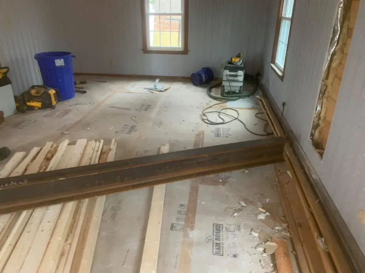 A room with a lot of wood on the floor and a window.