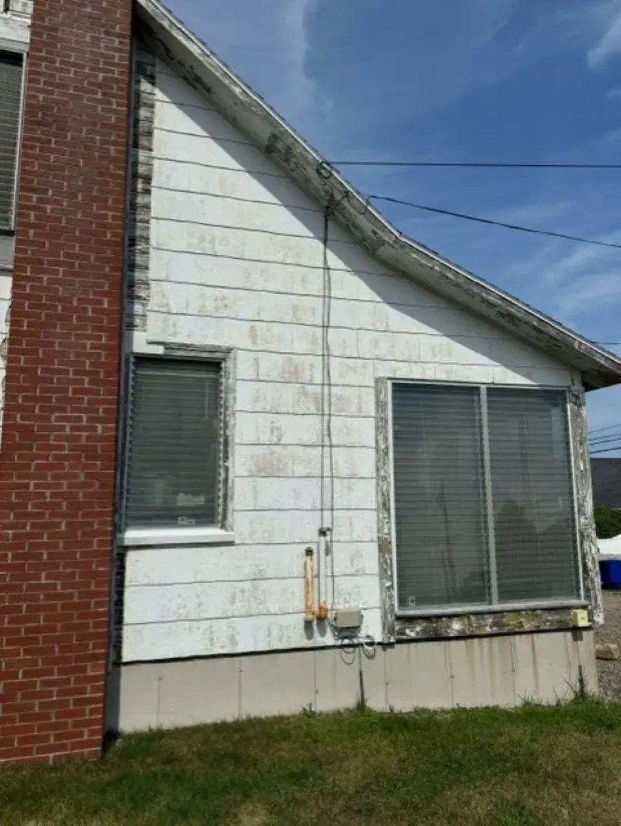 A white house with a brick chimney on the side