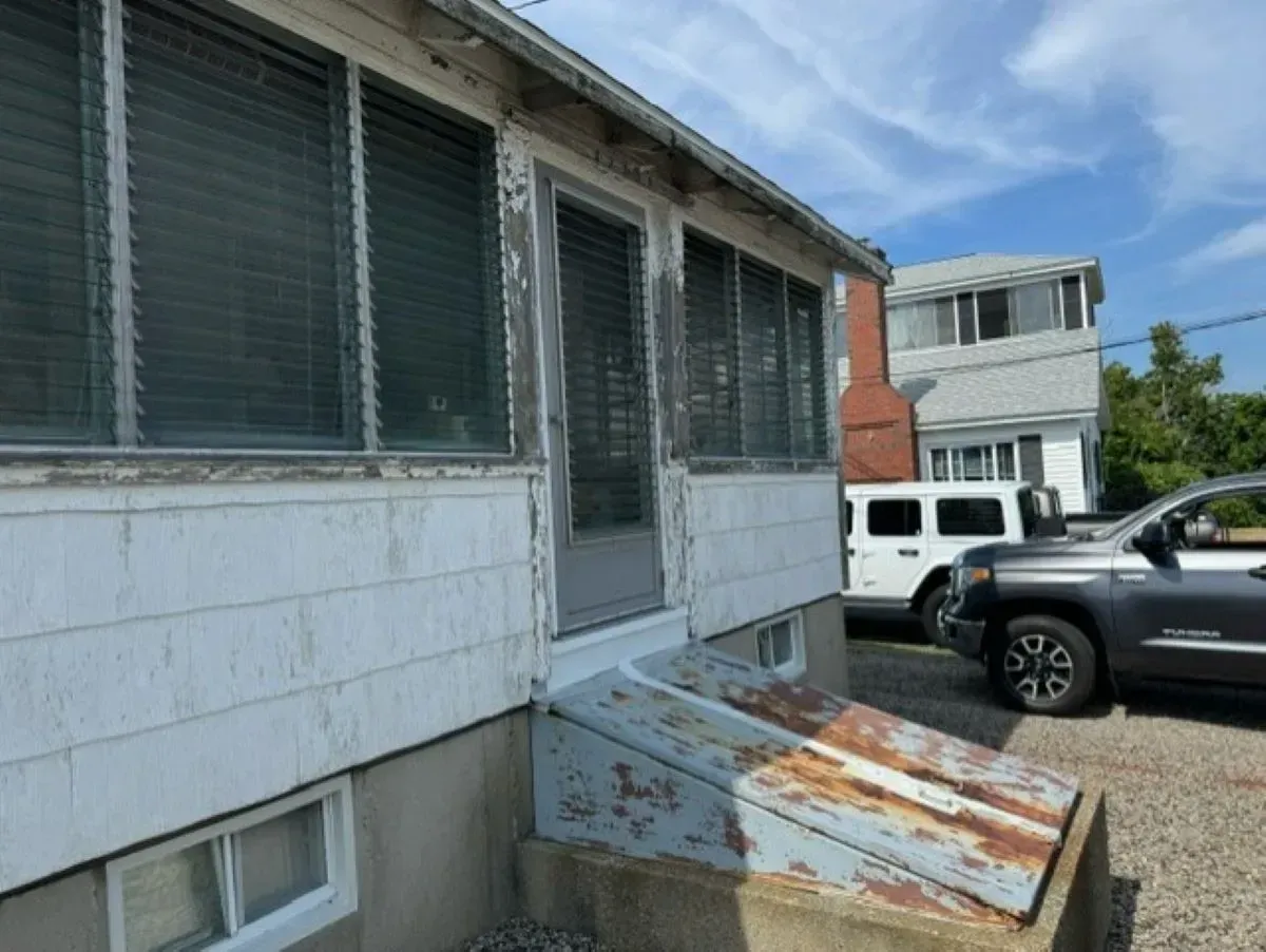 A jeep is parked in front of a white house