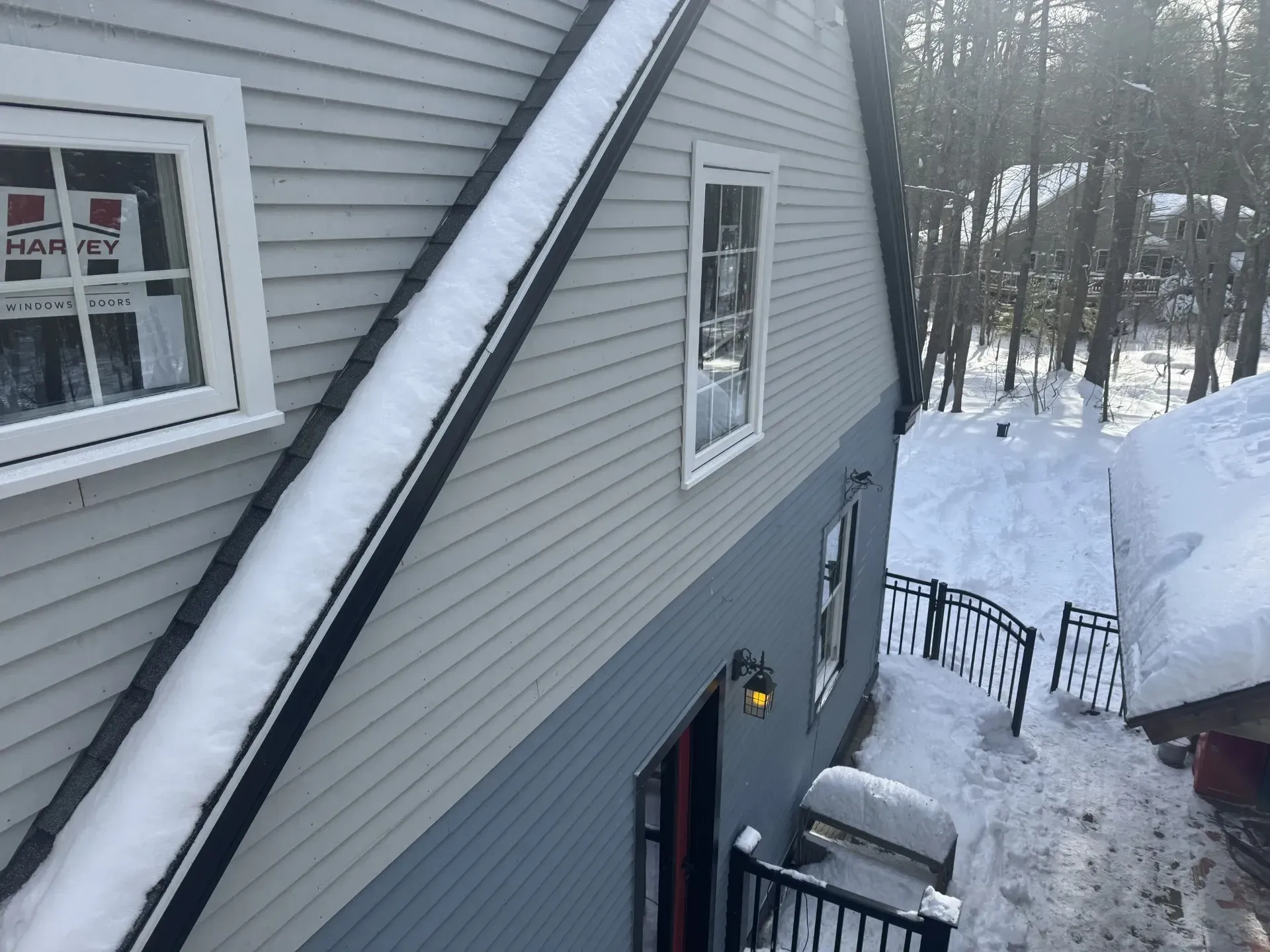A snowy house with a sign that says happy on it