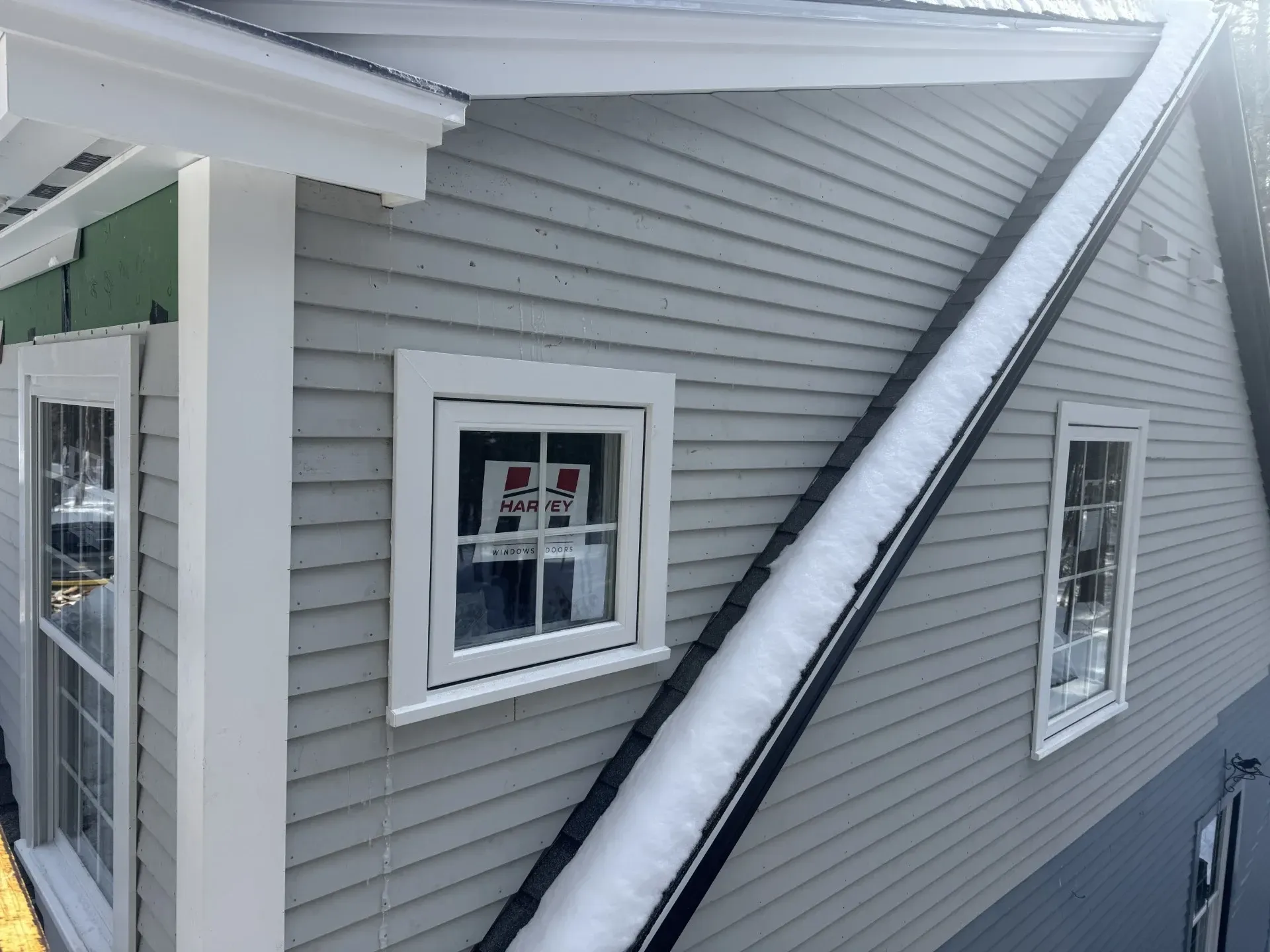 A house with a lot of windows and snow on the roof