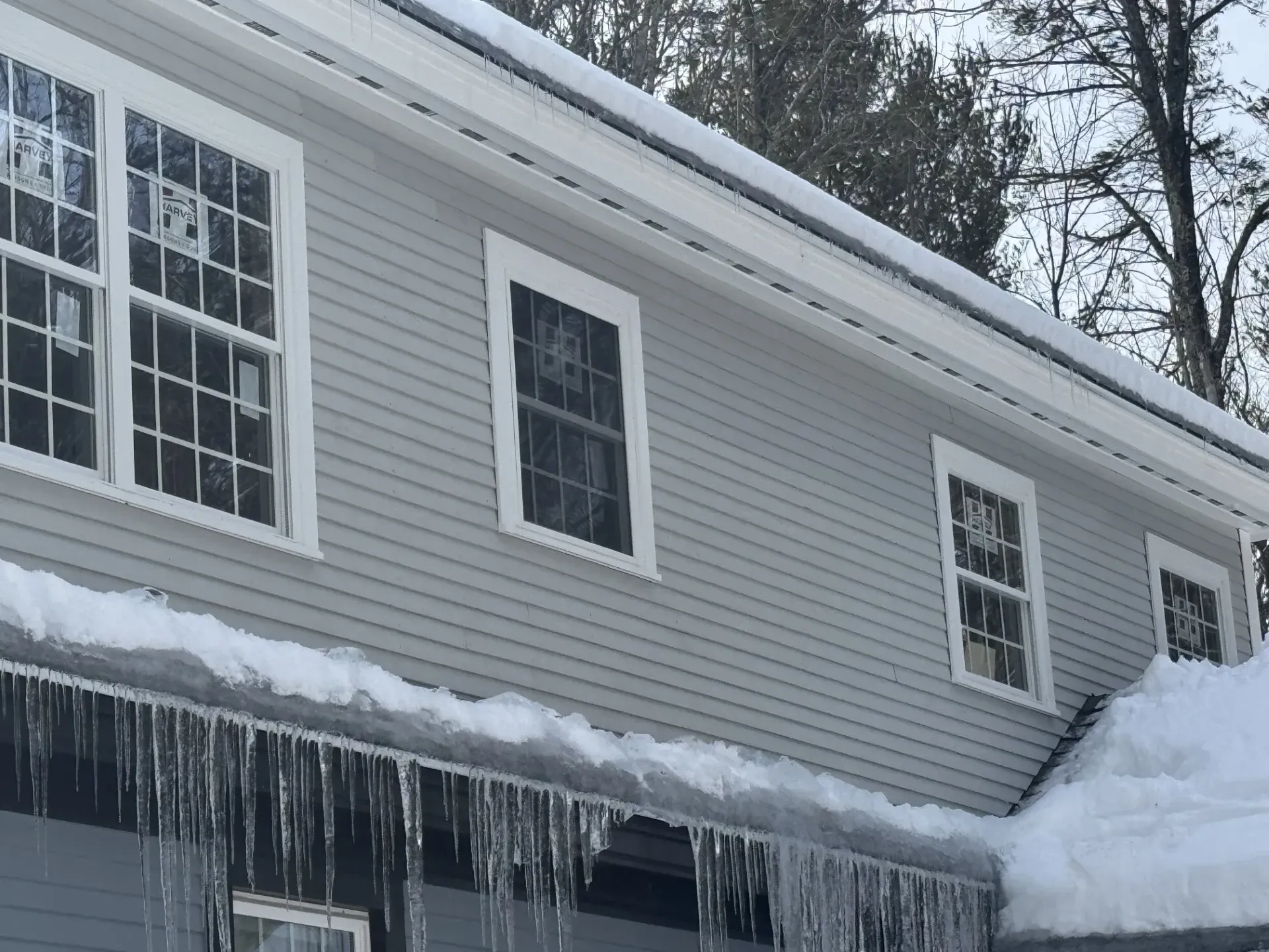 Icicles are hanging from the roof of a house