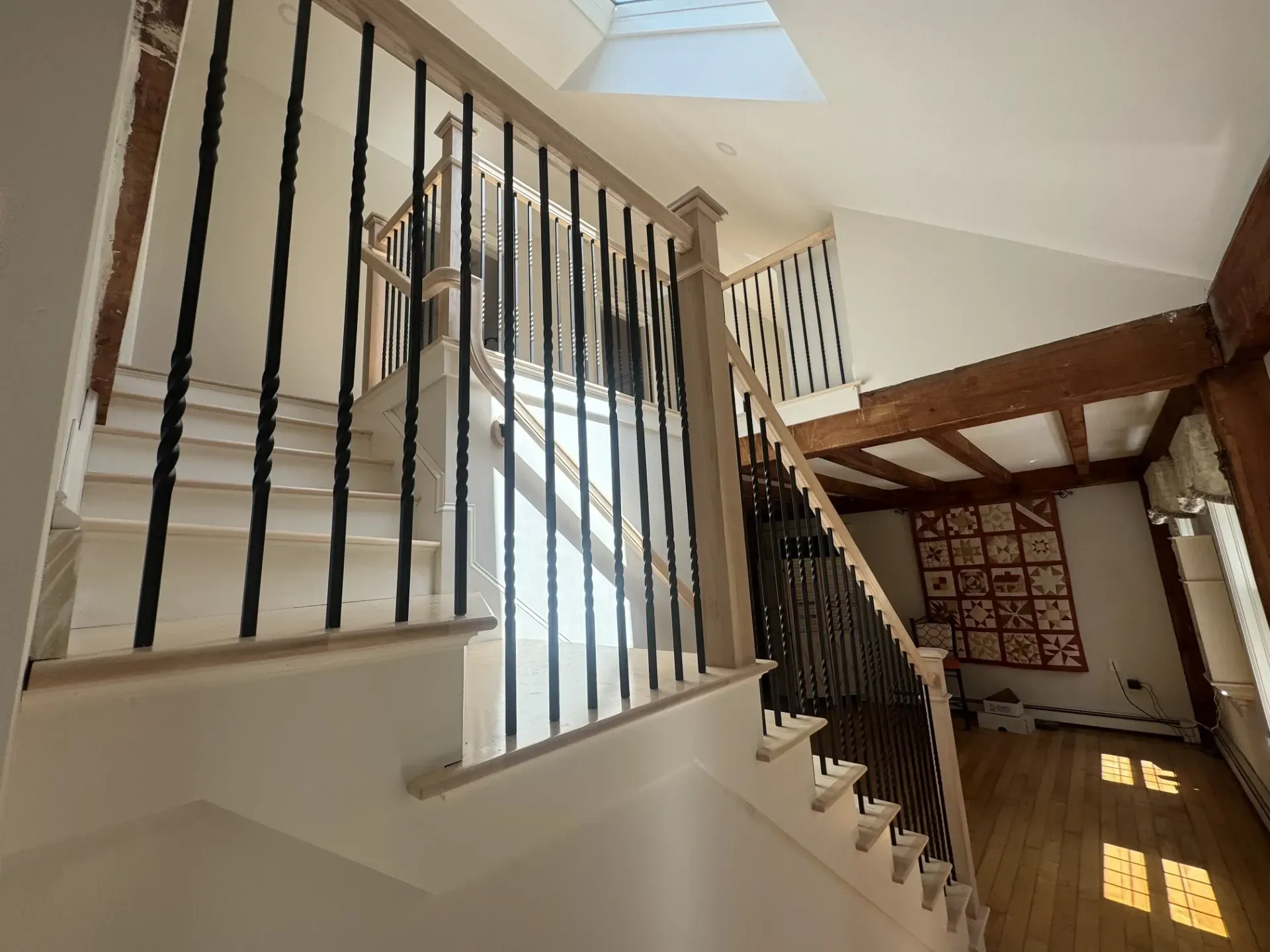 A staircase in a house with a skylight above it.