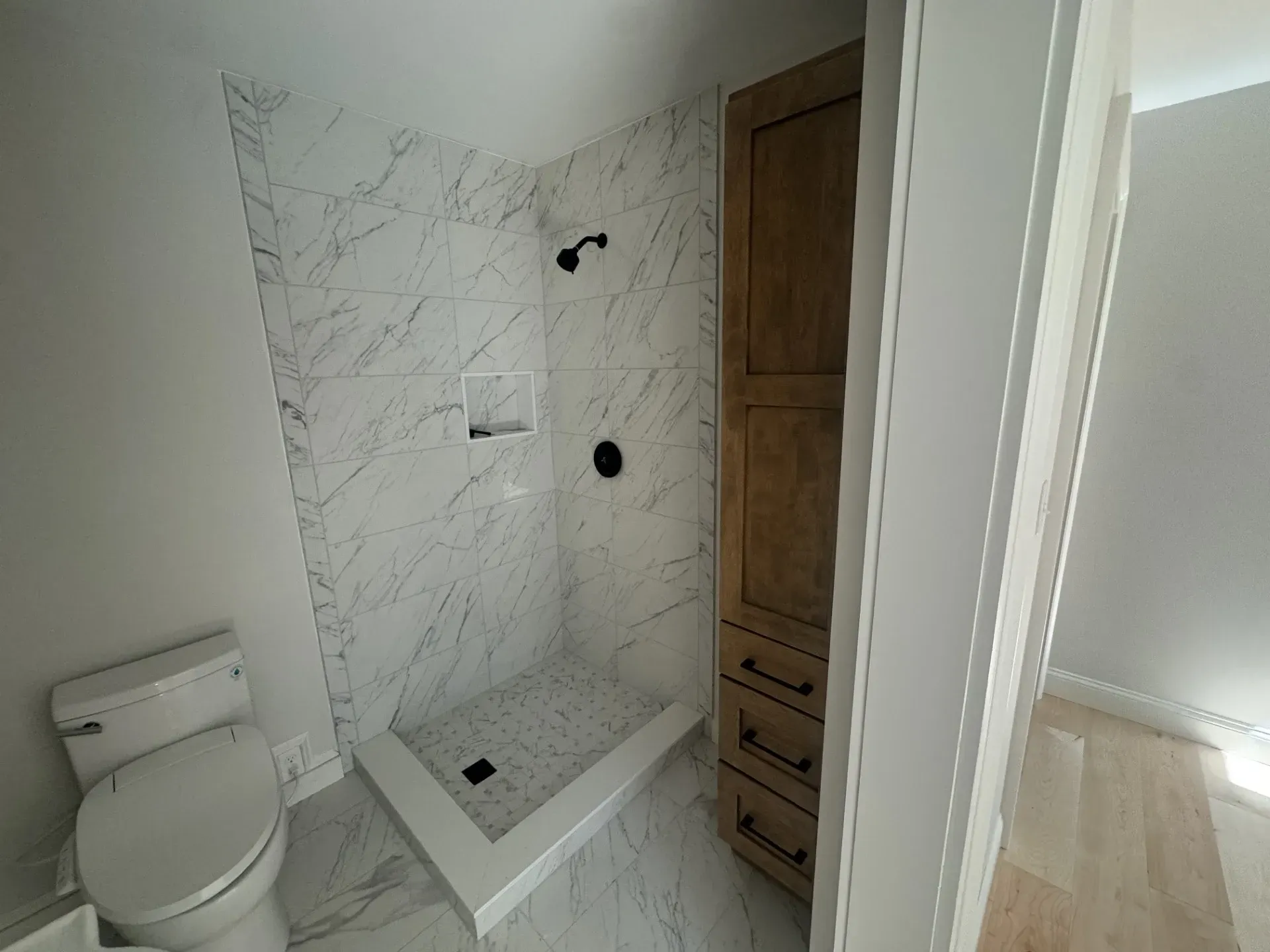 A bathroom with a toilet and a walk in shower.