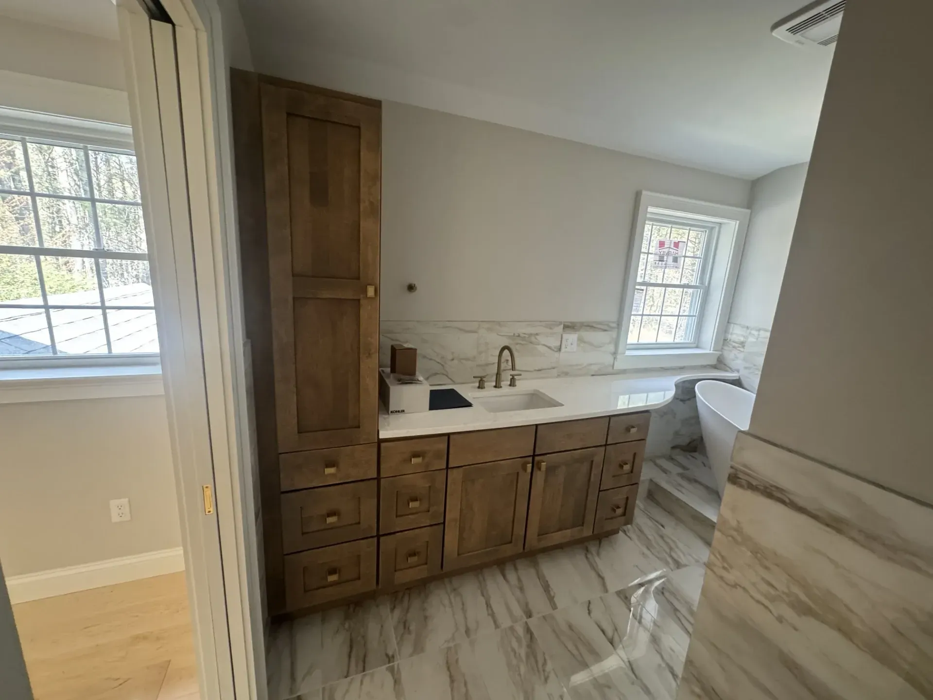 A bathroom with a sink , cabinets , and a tub.