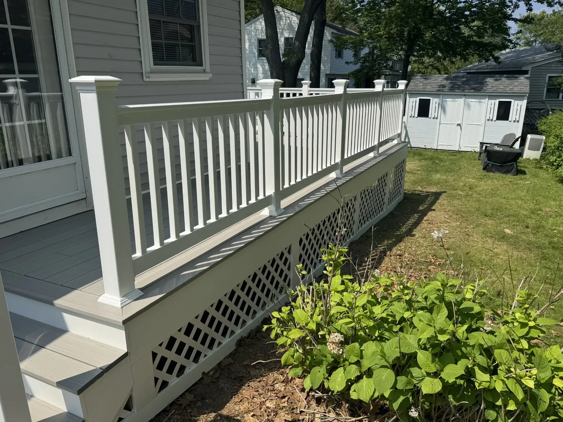 A white porch with a white railing and stairs
