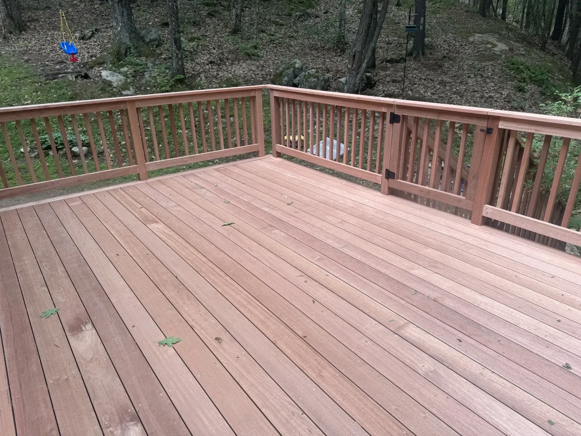 A wooden deck with a railing in the woods