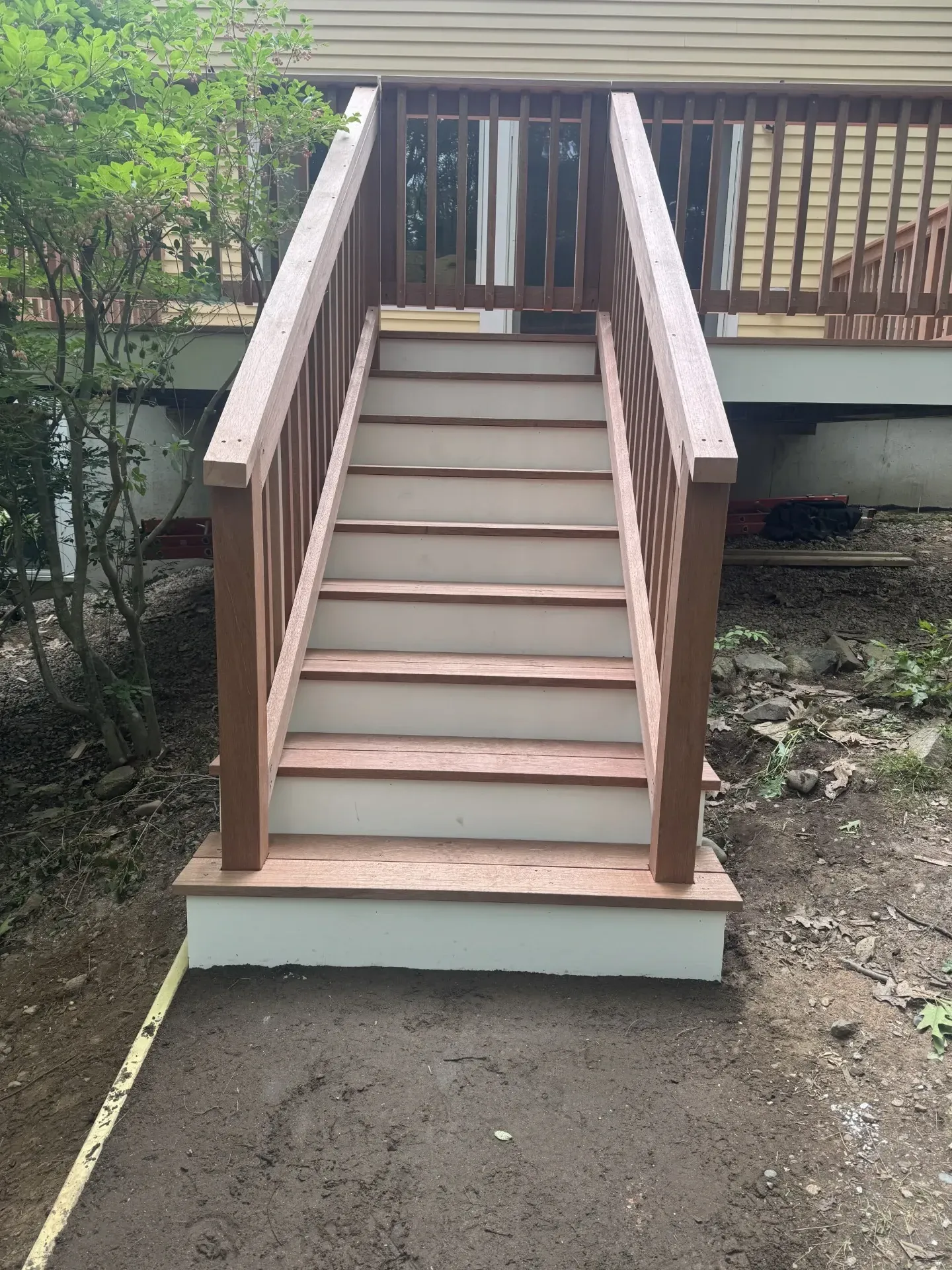 A set of stairs leading up to a deck with a wooden railing.