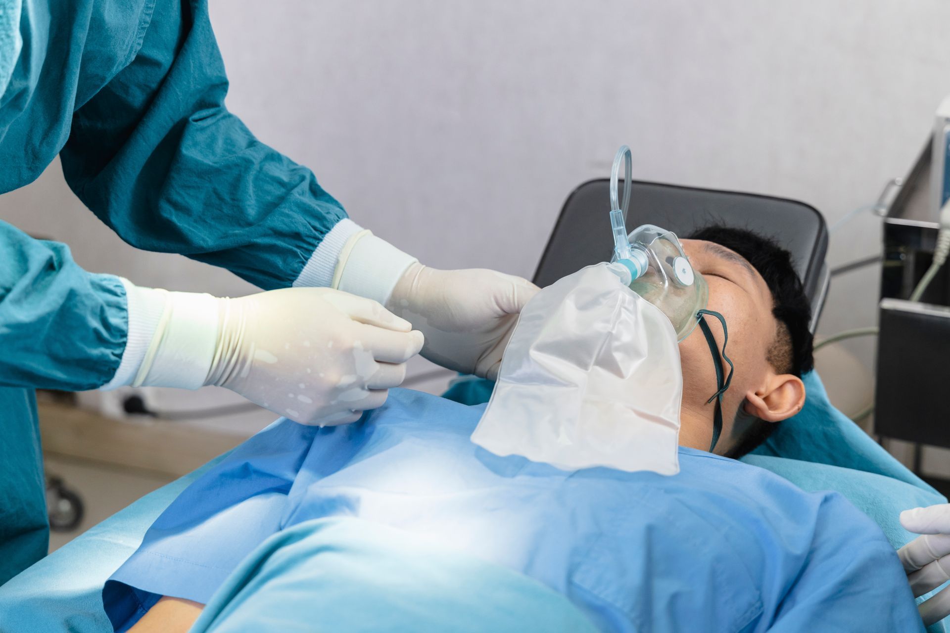 A person wearing an oxygen mask in a medical setting. Anesthesiologist adjusting the mask before surgery.