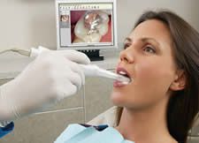 A woman is getting her teeth examined by a dentist.
