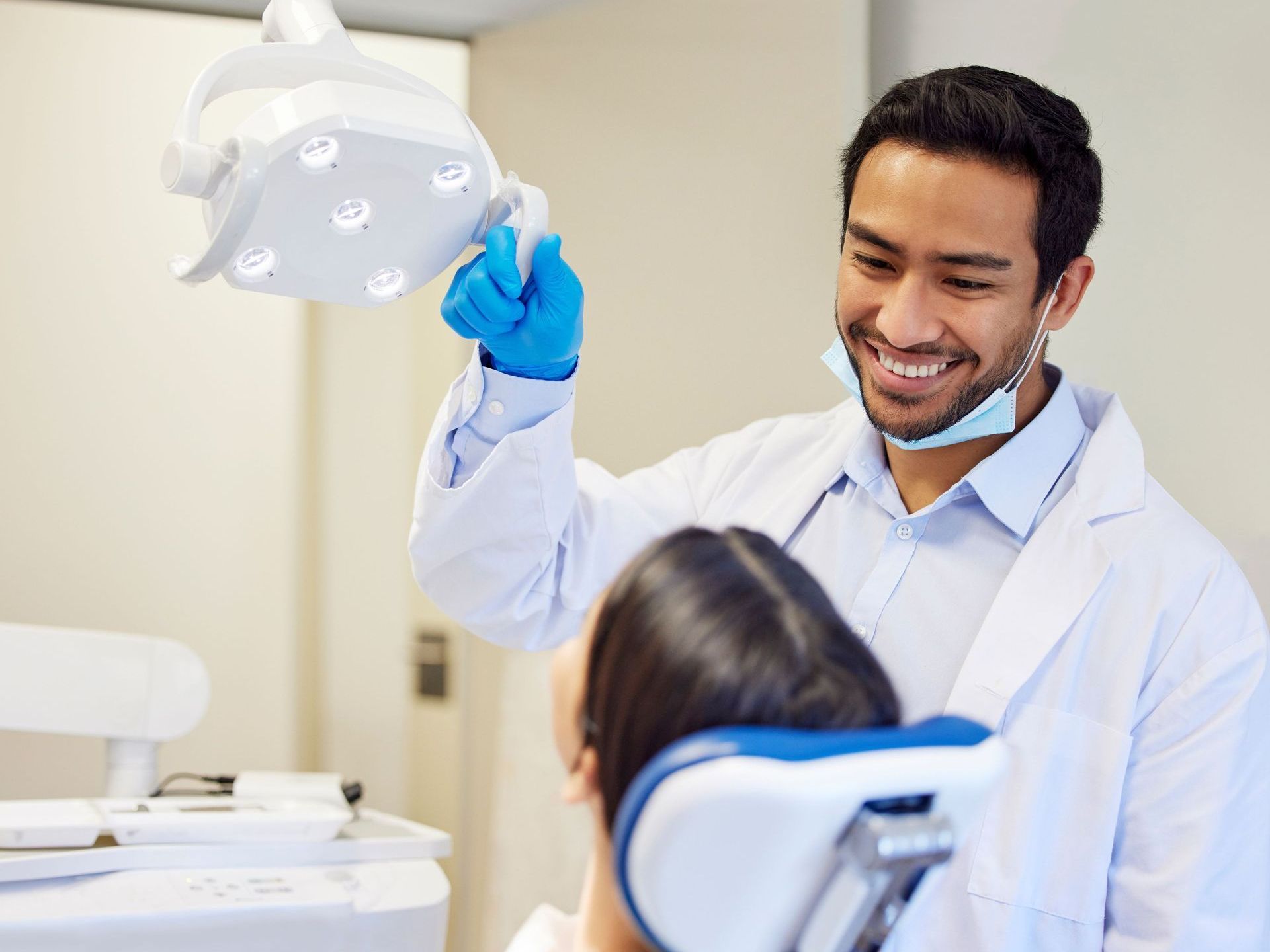 A dentist is examining a patient 's teeth in a dental office.