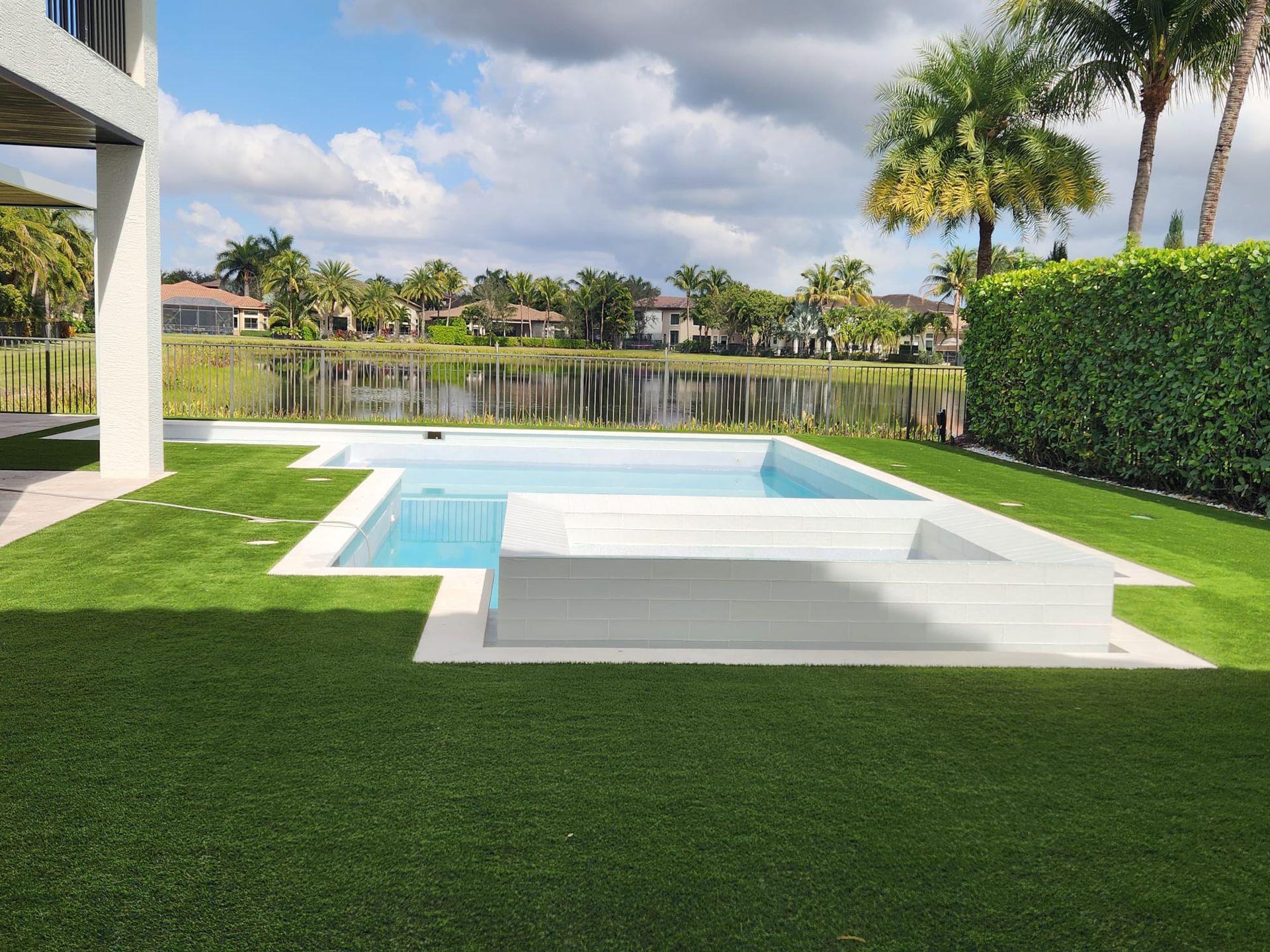 There is a large swimming pool in the backyard of a house.