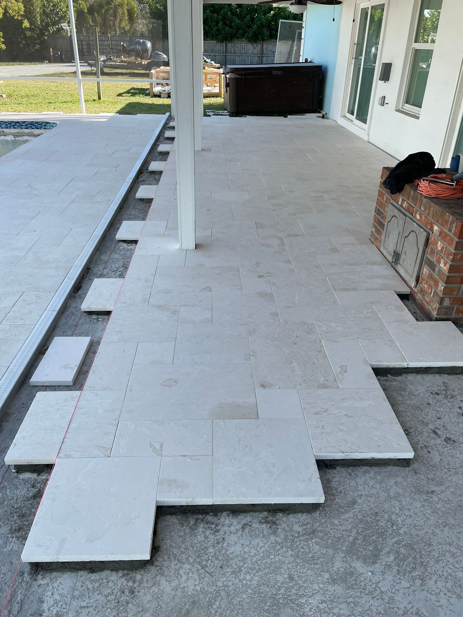 A patio with a hot tub in the background is being built.