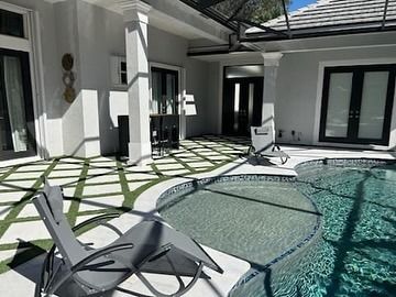 There is a swimming pool in the backyard of a house.