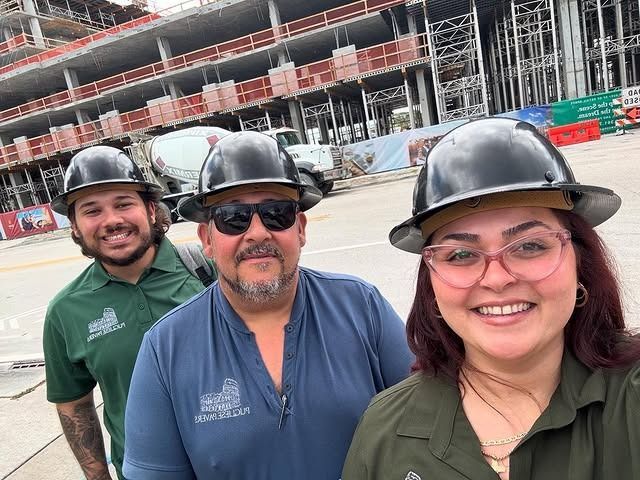 A group of construction workers wearing hard hats are posing for a picture.