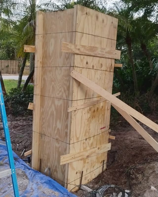 A large wooden structure is being built in the dirt