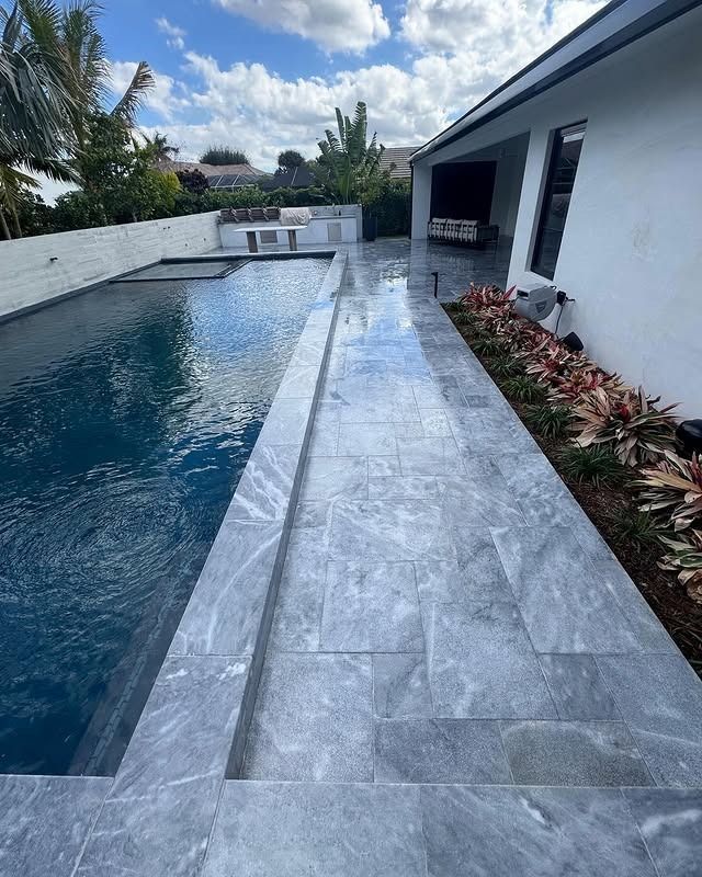 There is a large swimming pool in the backyard of a house.