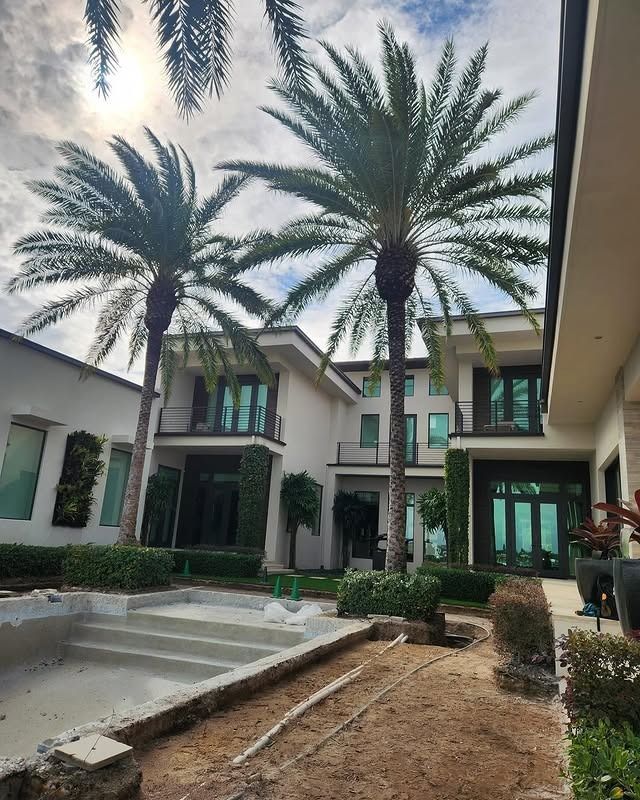 A large house with two palm trees in front of it.