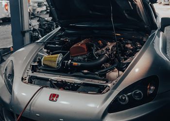 Silver Honda S2000 with hood open, engine exposed. Yellow air filter, red engine cover.