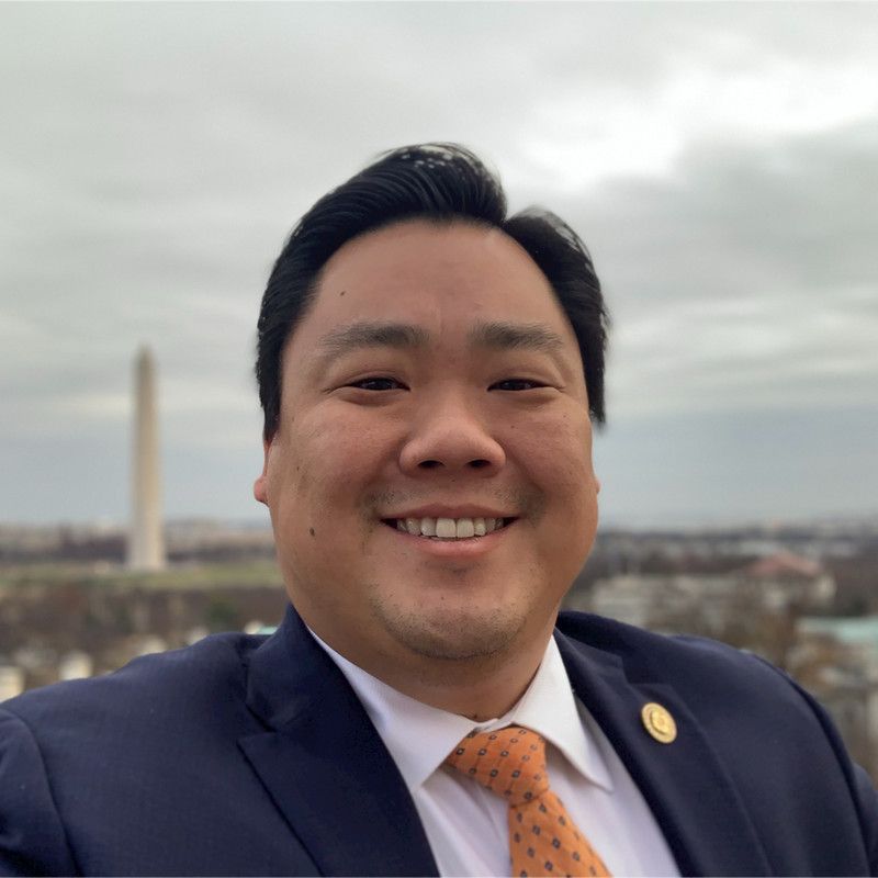 A man in a suit and tie smiles for the camera