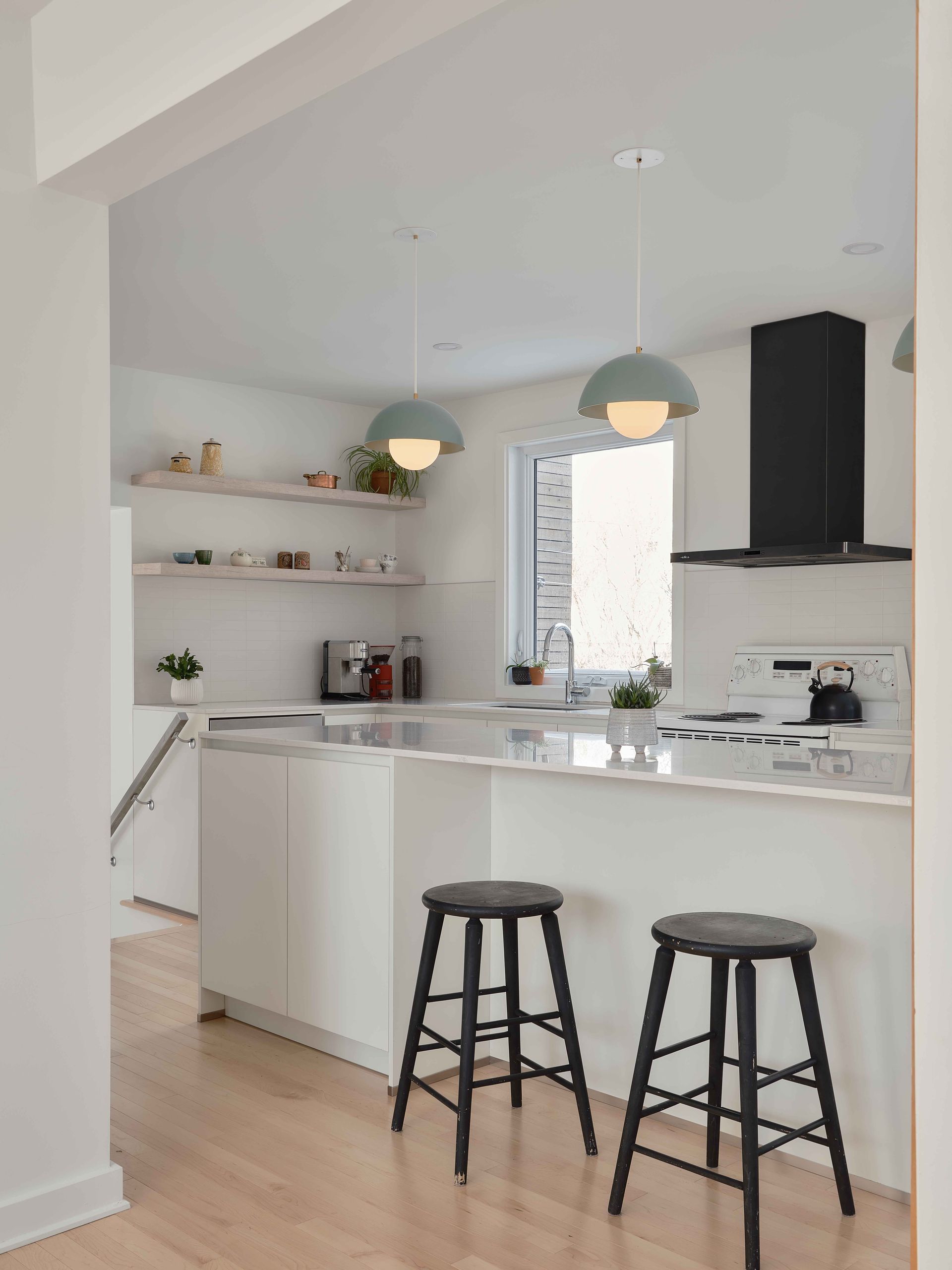 Une cuisine avec deux tabourets et un four à plaques de cuisson