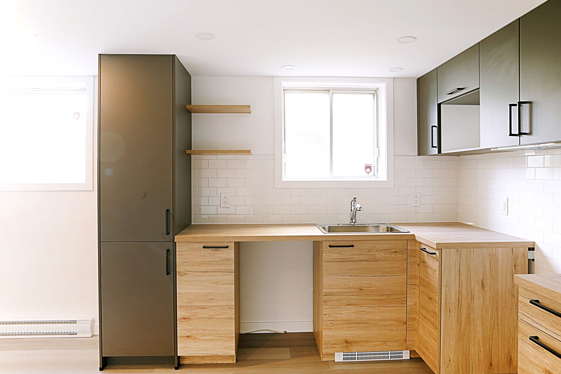 Une cuisine avec des armoires en bois, un évier et une fenêtre.