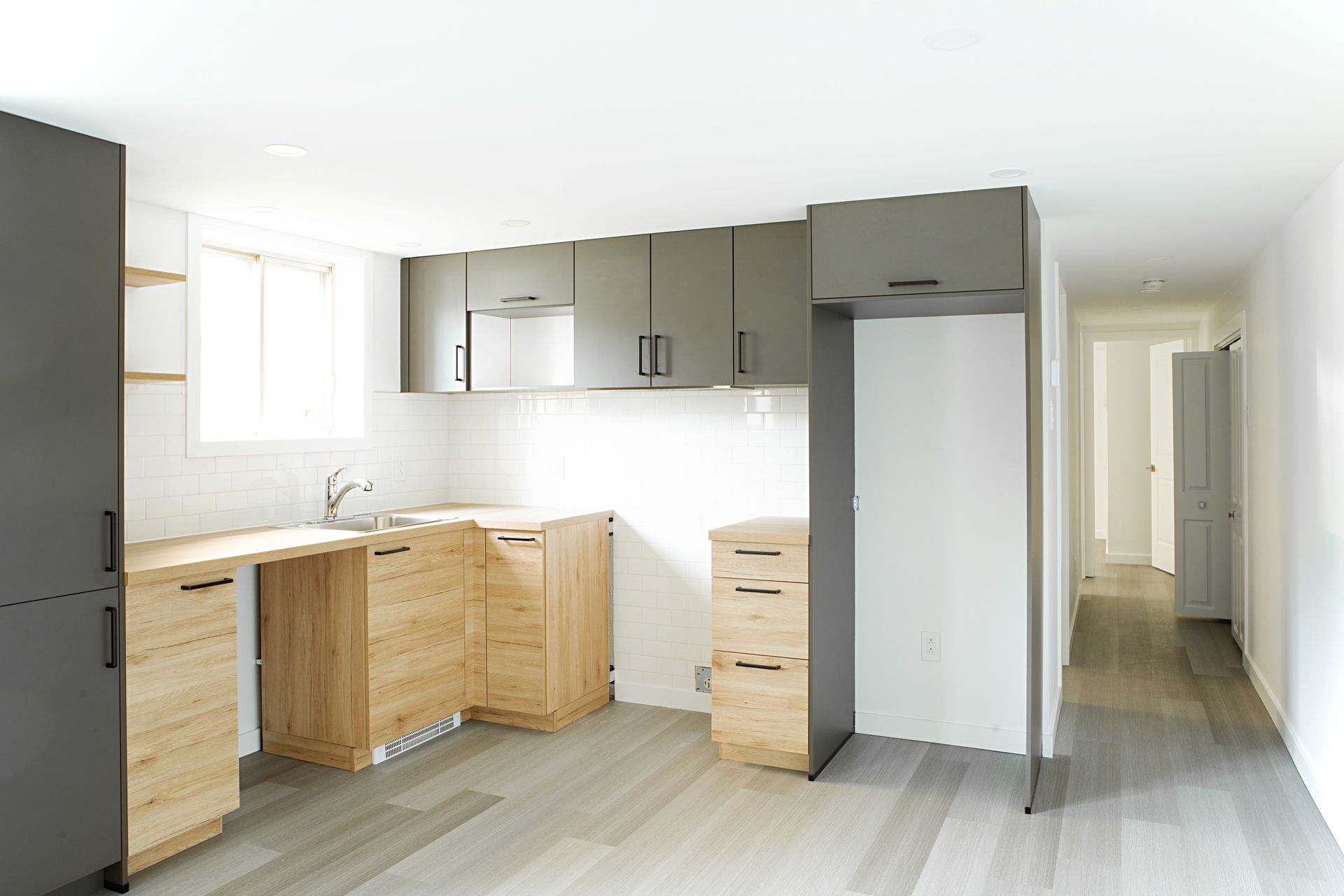 Une cuisine avec des armoires en bois et des murs blancs