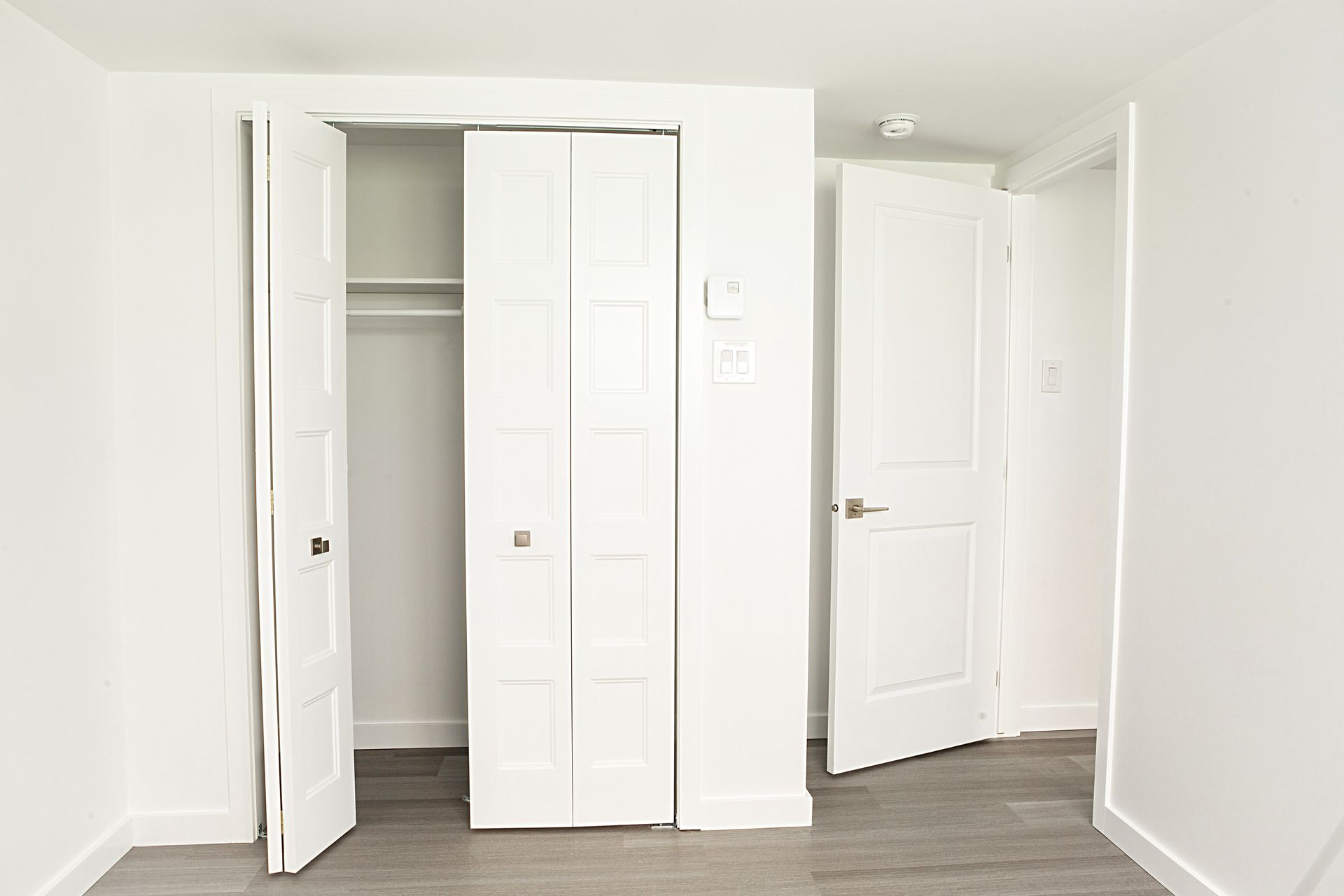 Une chambre vide avec un placard et deux portes ouvertes