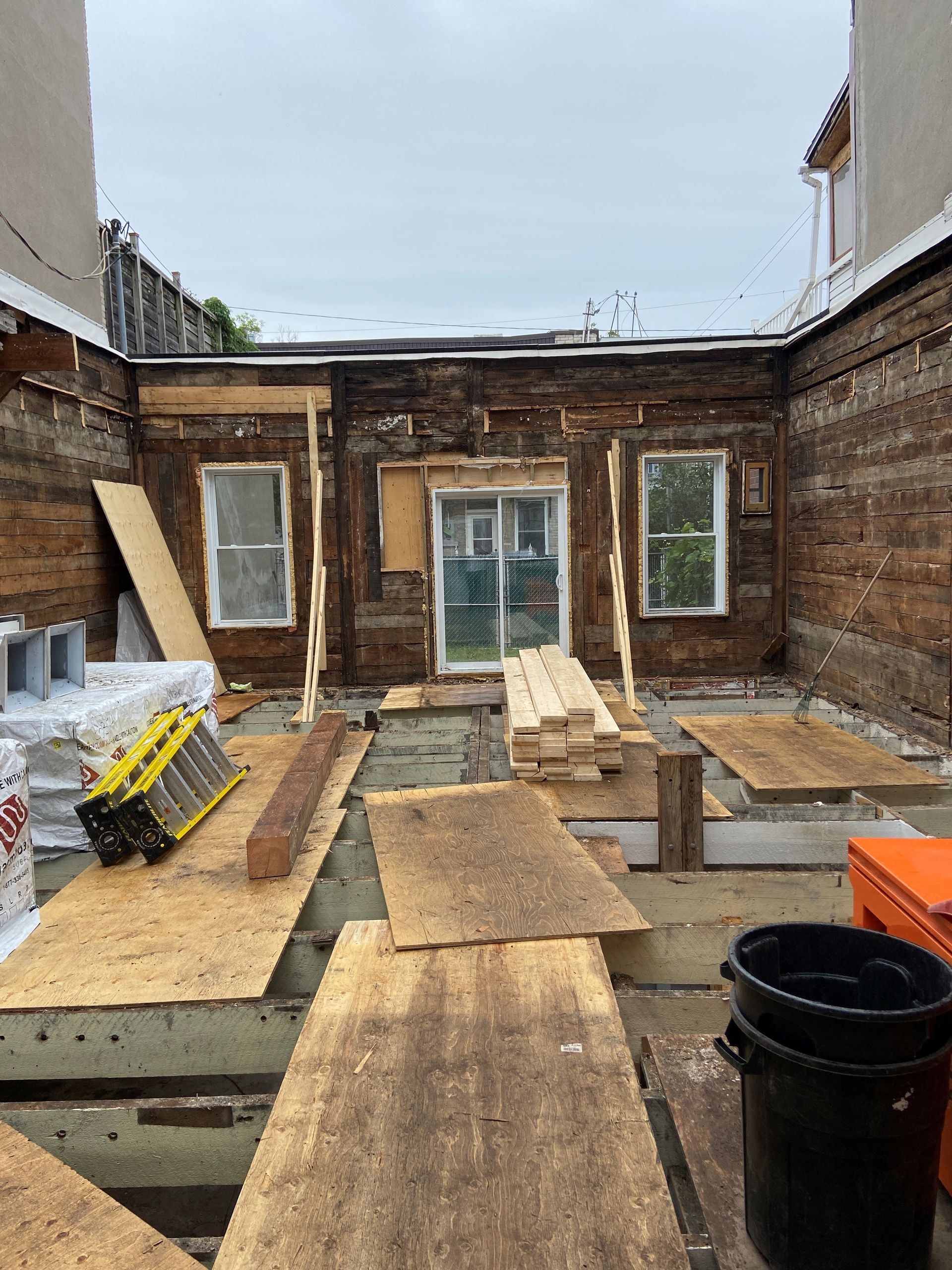 Un bâtiment en construction avec beaucoup de planches de bois et une échelle.