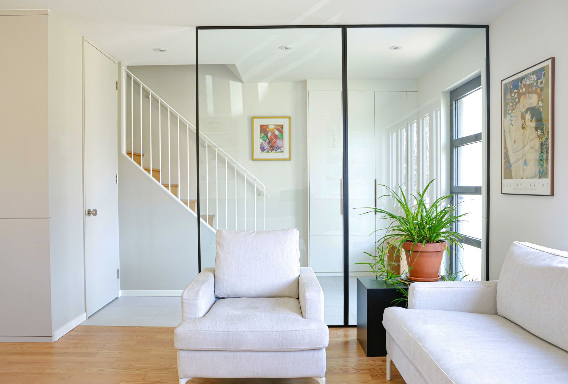 Un salon avec un canapé, une chaise et une plante en pot