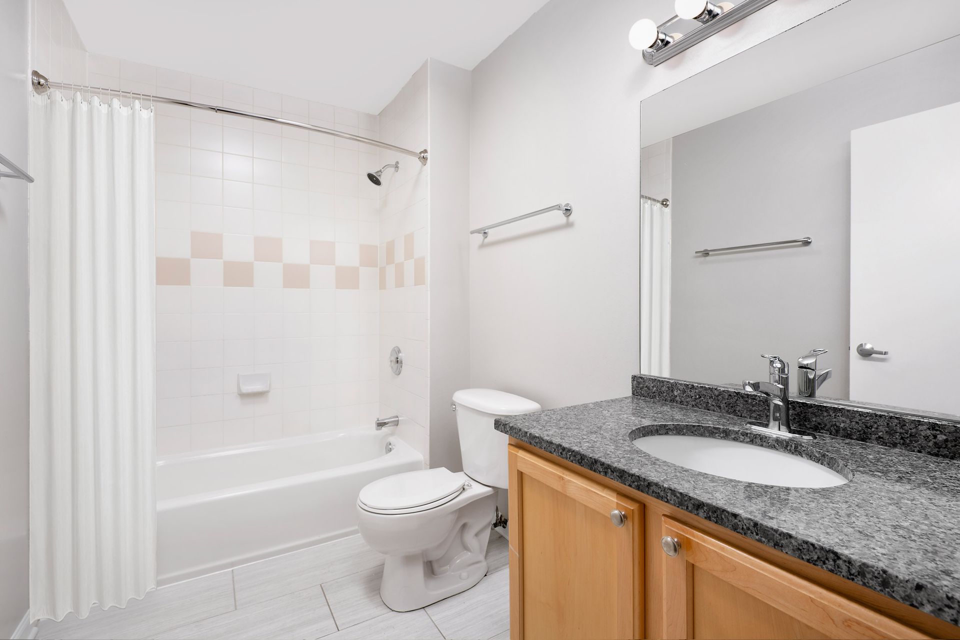 A bathroom with a sink, toilet, bathtub, and mirror at 2010 West Pierce Avenue.