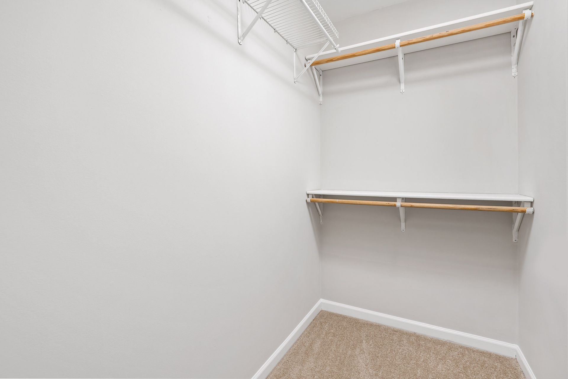 An empty walk-in closet with shelves and a carpeted floor at 2010 West Pierce Avenue.