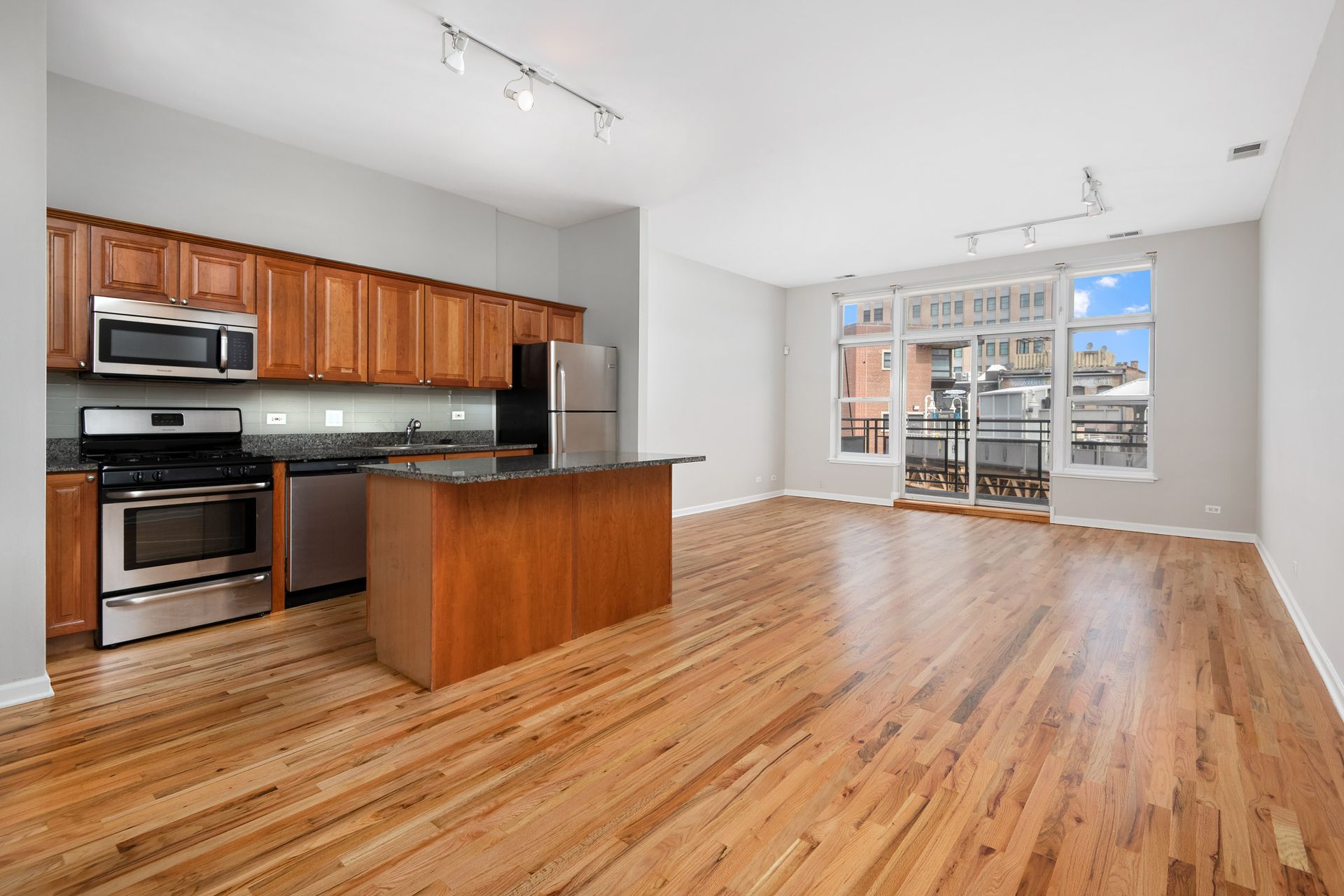 An empty kitchen with hardwood floors and stainless steel appliances at 2010 West Pierce Avenue.