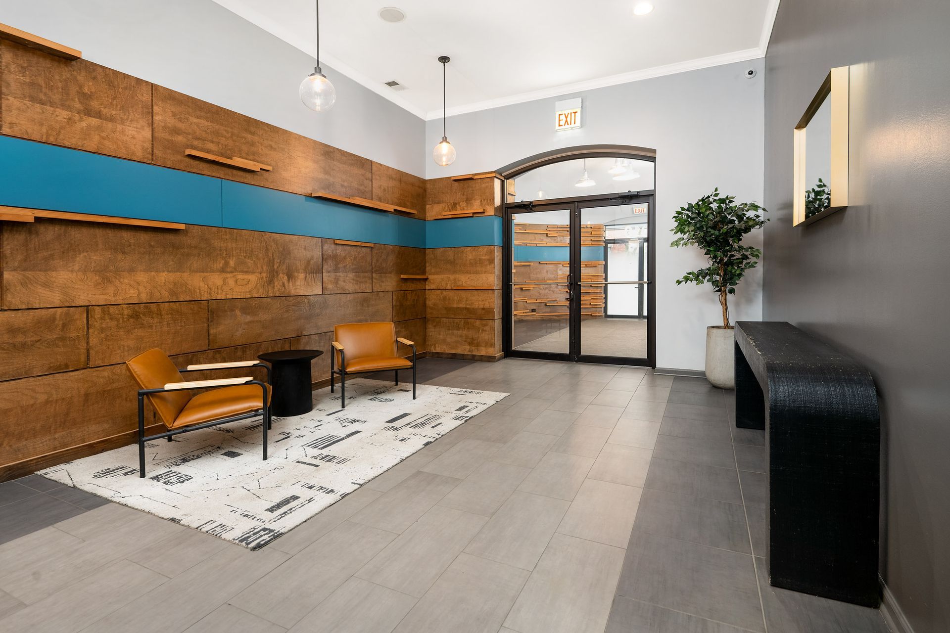 A lobby with wooden walls, chairs, a table, and a plant at 2010 West Pierce Avenue.
