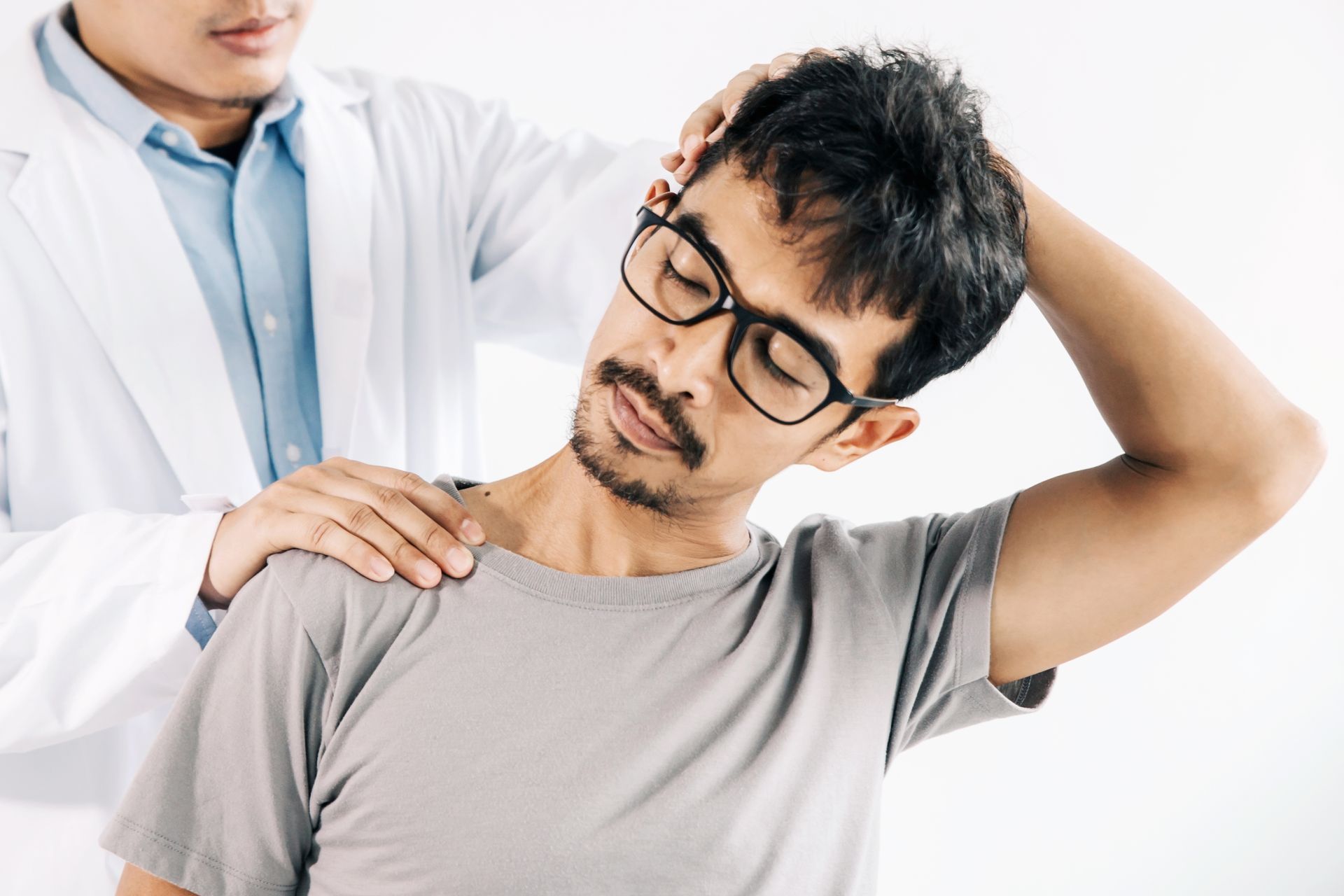 A healthcare professional gently assists a patient in stretching their neck to the side.